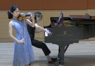 Dana Chang playing violin on stage, remembering her musical legacy.